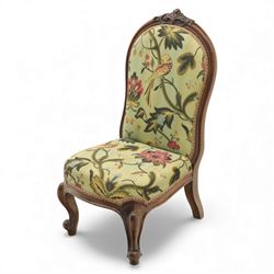 Small Victorian mahogany nursing chair, with carved top rail above a padded balloon back and shaped seat upholstered in light green fabric detailed with exotic birds and flowering vines, raised upon cabriole front legs and turned rear supports