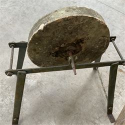 Vintage grindstone sharpening wheel mounted on metal stand, and a cast iron water pump