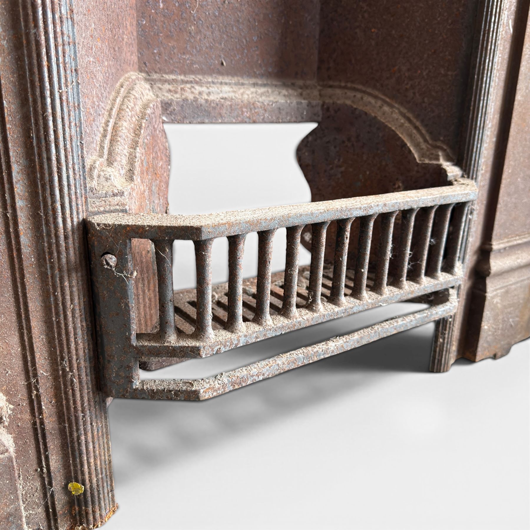 Late Victorian cast ion bedroom fireplace, decorated with floral poppy motifs and flluting