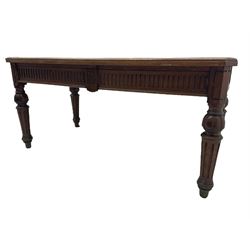 Late 19th century oak library table, moulded rectangular top with canted corners, fitted with two frieze drawers with fluted facias, on lobe carved and fluted turned supports 