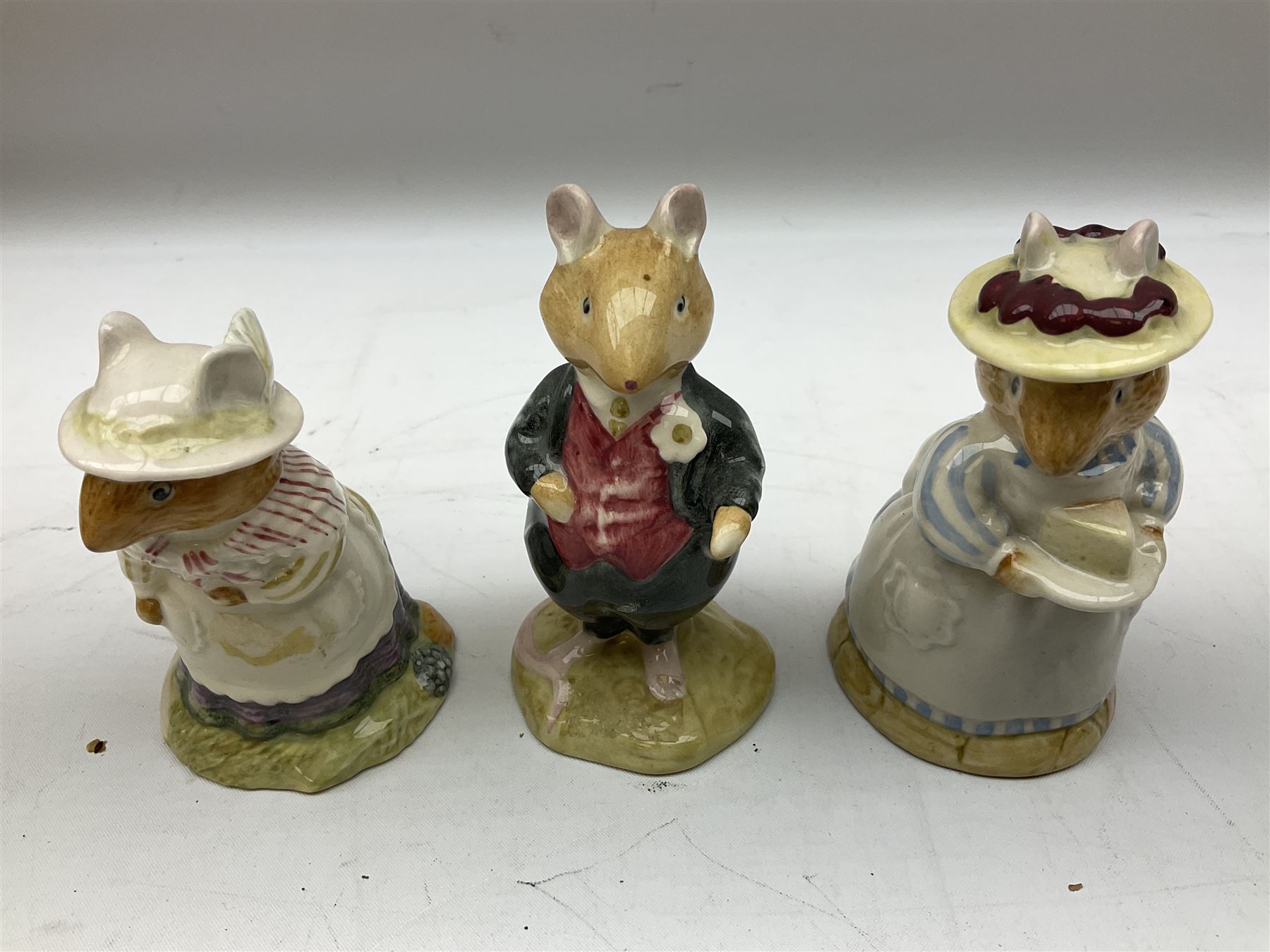 Fifteen Royal Doulton Brambly Hedge figures, comprising Wilfred Toadflax, Dusty Dogwood, Mrs Toadflax, Mr Apple, Primrose Woodmouse, Lord Woodmouse, Poppy Everbright, two Lady Woodmouse, two Old Mrs Everbright, Mr Toadflax, Mrs Apple, Santa Bunnykins and Bunnykins, together with three Royal Albert Wind in the Willows figures comprising Ratty, Badger and Mole, all with printed marks beneath (18)