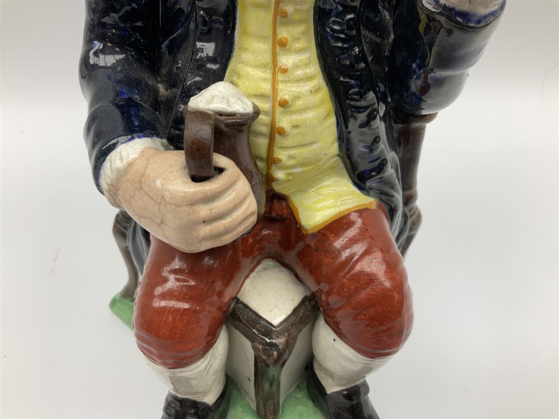 Early 20th century Staffordshire William Kent Squire toby jug, modelled seated upon a corner chair holding a jug of ale in his right hand, H28cm