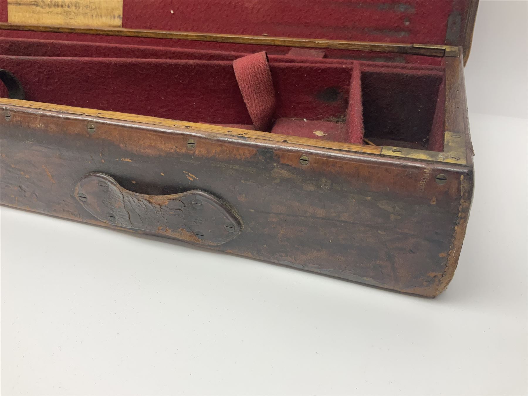 Leather shotgun case, the red baize lined interior with the trade labels of Westley Richards & Co., London, a brass plaque inscribed 'T Nevin, Mirfield, Yorkshire' to cover, with key, case to fit barrel 76cm (30 inches)  
