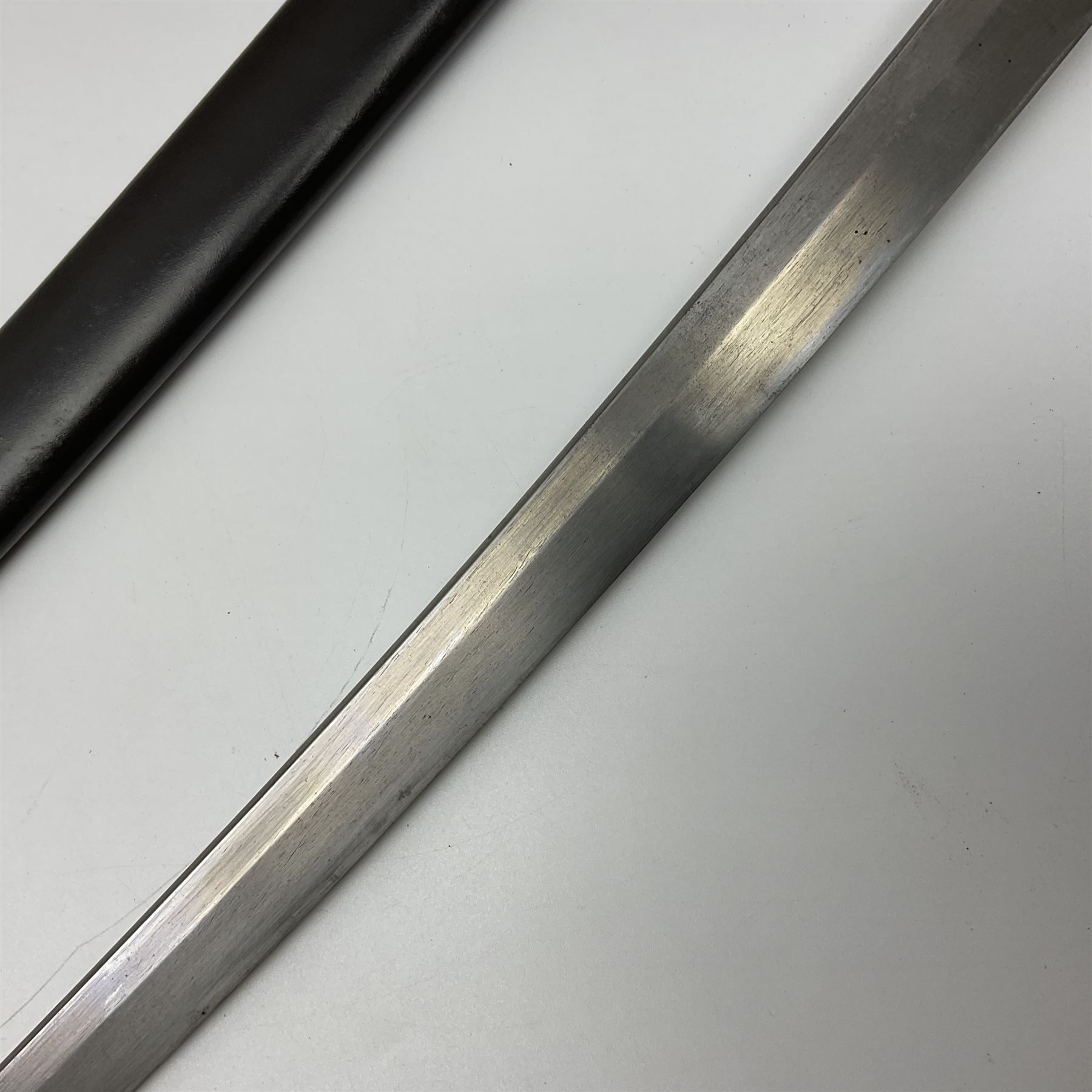 WW2 Japanese Army officer's shin gunto/katana sword with 68.5cm steel single edged blade, foliate cast brass tsuba, bound fish-skin grip with brass mounts, inscribed marks to both sides of tang; in lacquered wooden scabbard with brass mounts and locking button L97cm overall