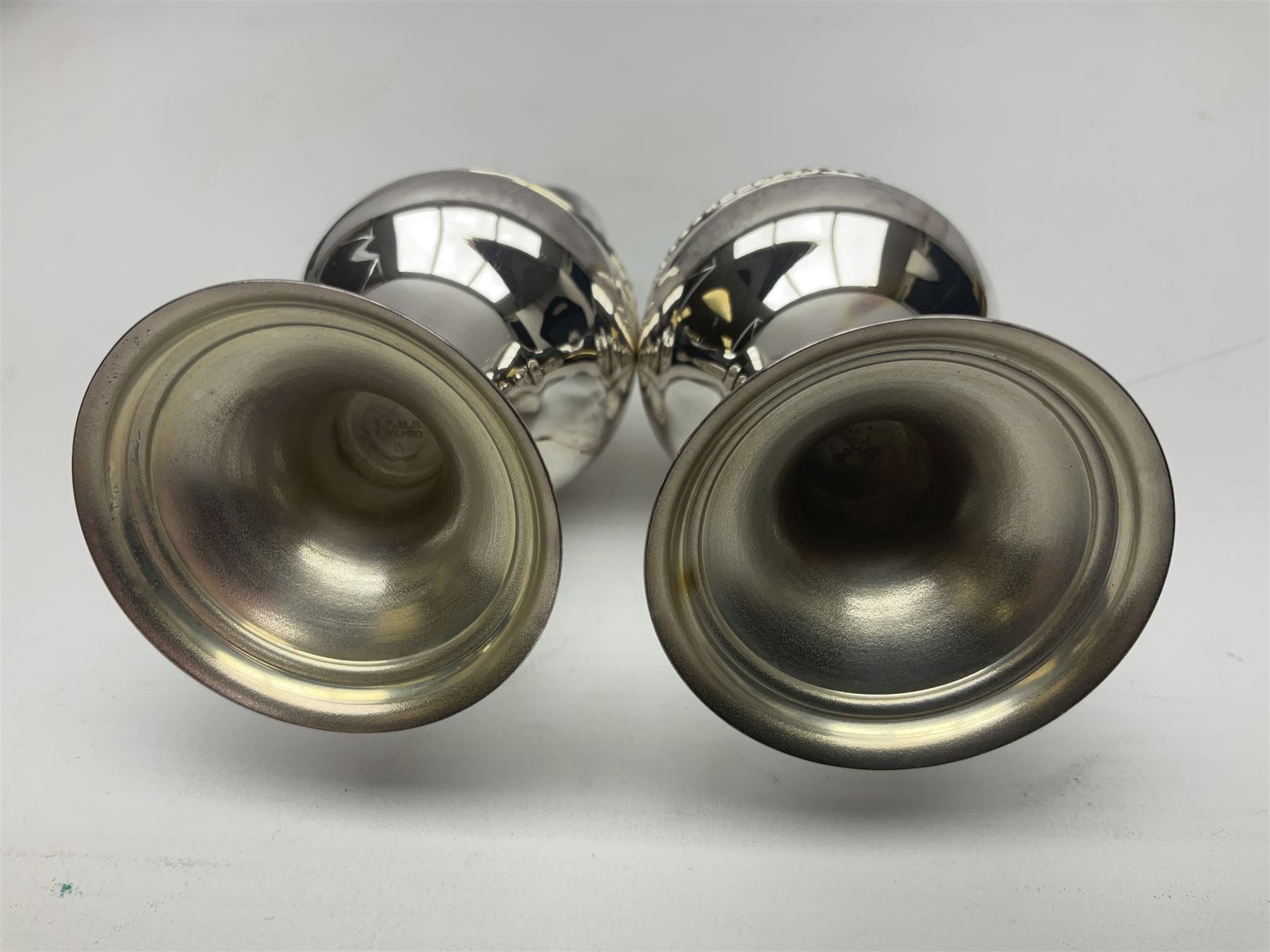 Silver plated two piece cruet set, comprising salt shaker and pepper shaker, both of waisted form with engraved rope twist borders, the removable pierced covers each with engraved lattice decoration, upon a circular spreading foot, H13.3cm, contained within velvet lined fitted case