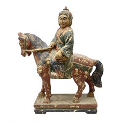 Large carved wood painted figure of warrior on horseback, decorated in red, blue and green, raised upon rectangular plinth base, H75cm W60cm