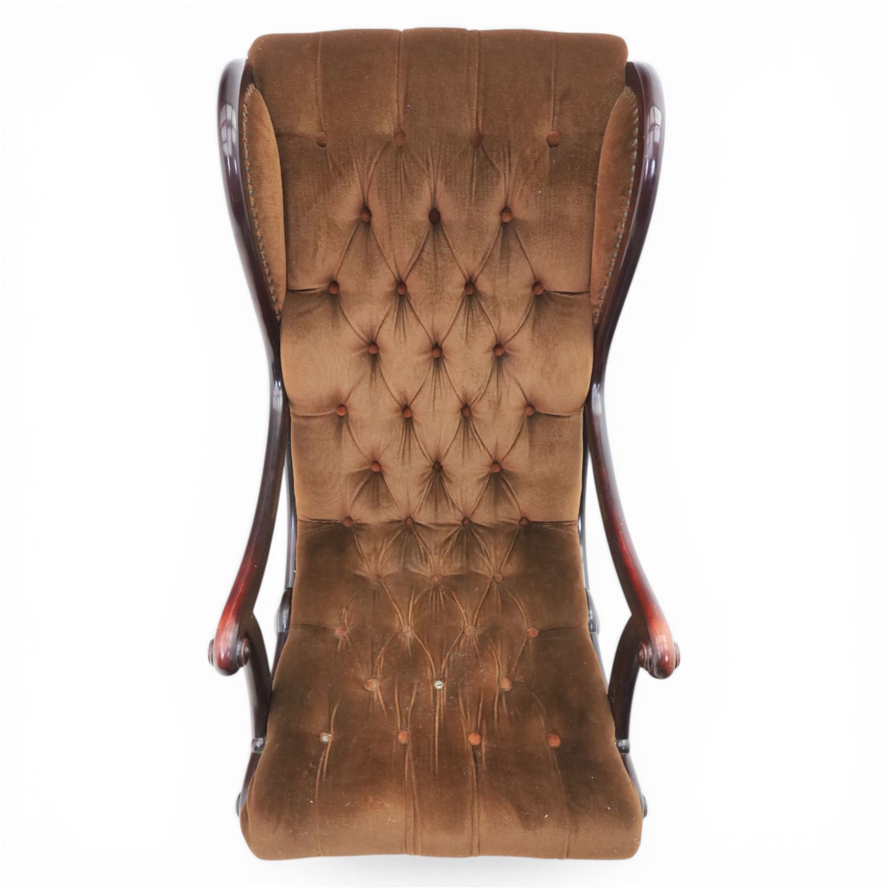 Late 20th century Regency style mahogany framed reading chair, the shaped and moulded frame with scrolled arms and open sides, upholstered in buttoned brown velvet, raised on curved supports terminating in scroll feet