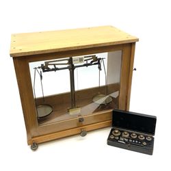 Set of Baird & Tatlock laboratory scales in oak case with rise-and-fall glazed front W39cm H36cm; with bakelite case of weights