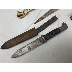 Indian kukri with 29cm curving steel blade and nickel mounted horn grip; in leather covered scabbard with one skinning knife L42cm overall; Hitler Youth knife with scabbard in relic condition; and three African graduated knives each with crudely carved wooden grips and painted leather covered scabbards (5)