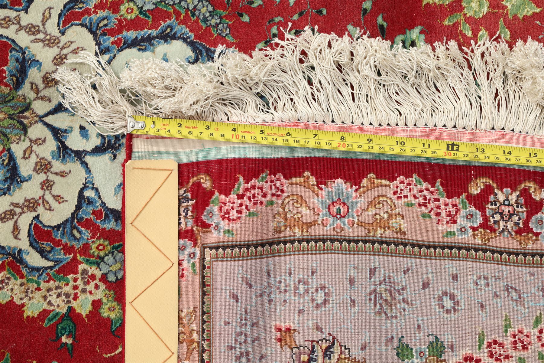 Persian silk inlaid crimson ground Kashan rug, the central shaped field with a floral pole medallion surrounded by trailing floral motifs and festoons of flowerheads, the wide cyan guard line with repeating palmettes and scrolling floral vines