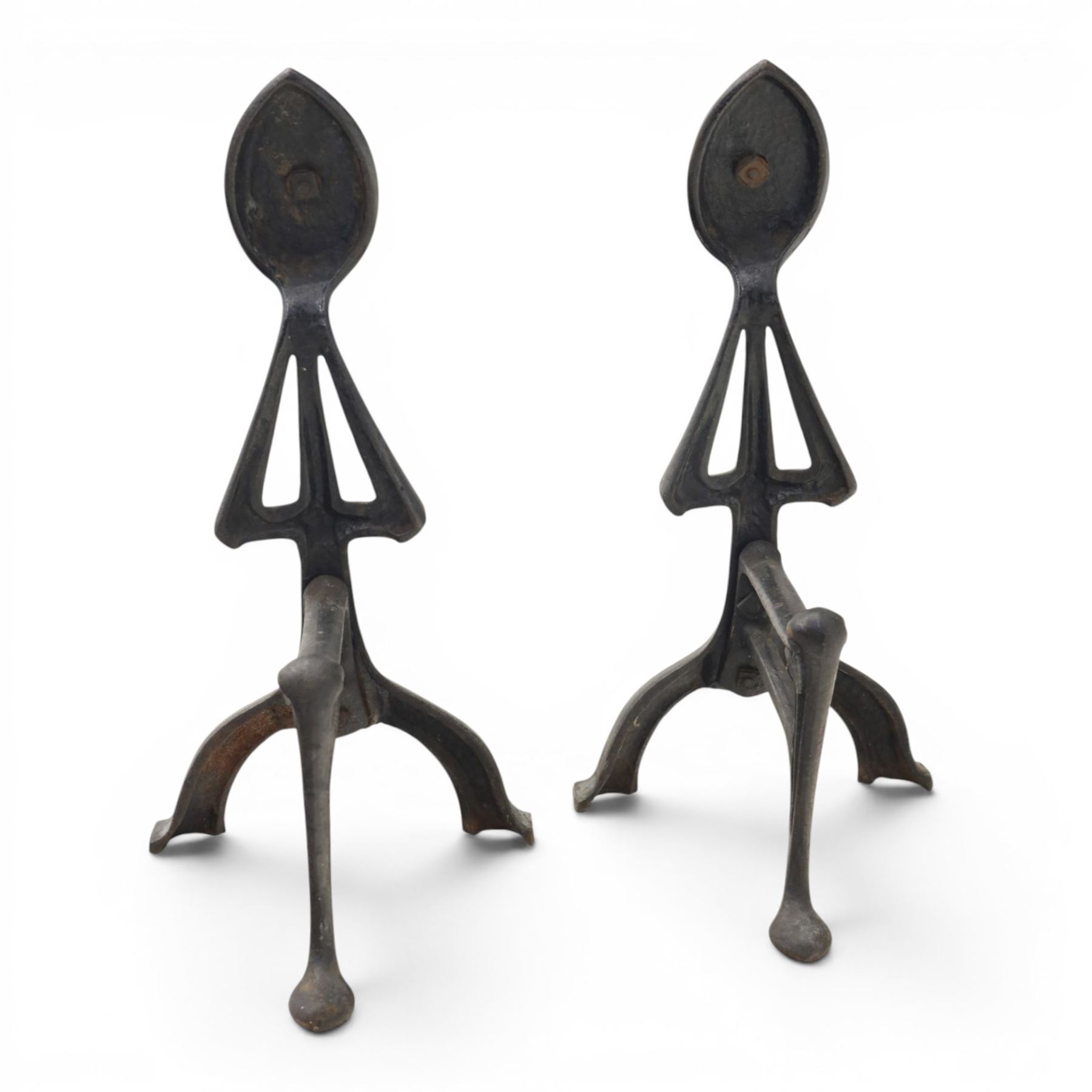 Arts and Crafts cast iron and brass andirons, brass and copper acorn finials above openwork uprights, raised on shaped arched feet with hammered detail
