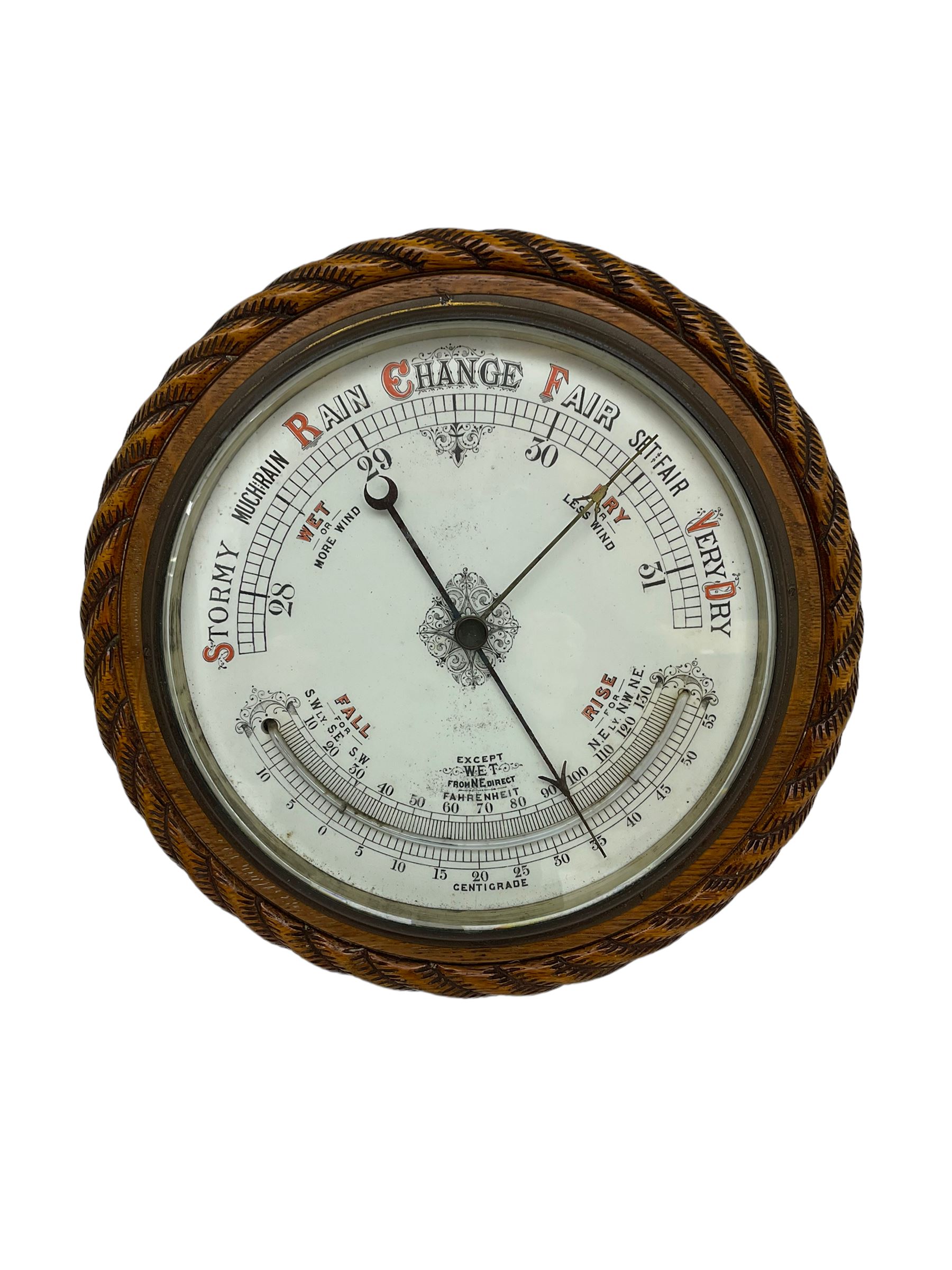1930’s aneroid barometer with a 10” porcelain dial recording barometric air pressure from 28 to 31 inches with weather predictions, curved mercury thermometer, steel indicating hand and brass recording hand, oak case with carved rope work decoration.