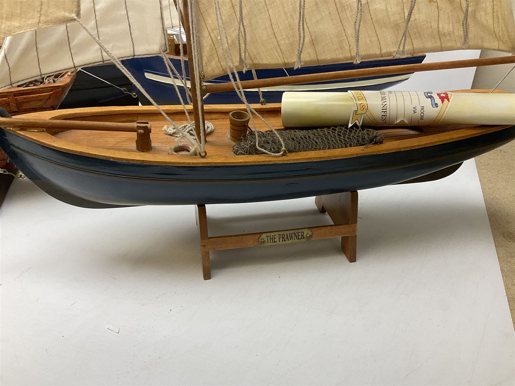 Eight model ships or boats including fishing boat with fish, nets and buoyancy aid, two mast sailing ship complete with cannons, two mast yacht with detailed rigging and life boat etc, the largest L72cm, H60cm