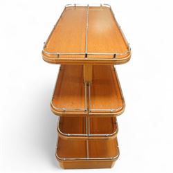 Mid-20th century retail display stand, of stepped rectangular tiered form with four graduated adjustable shelves, each with rounded corners and fitted with tubular chrome safety rails, supported by central chrome-mounted wooden uprights over a plinth base