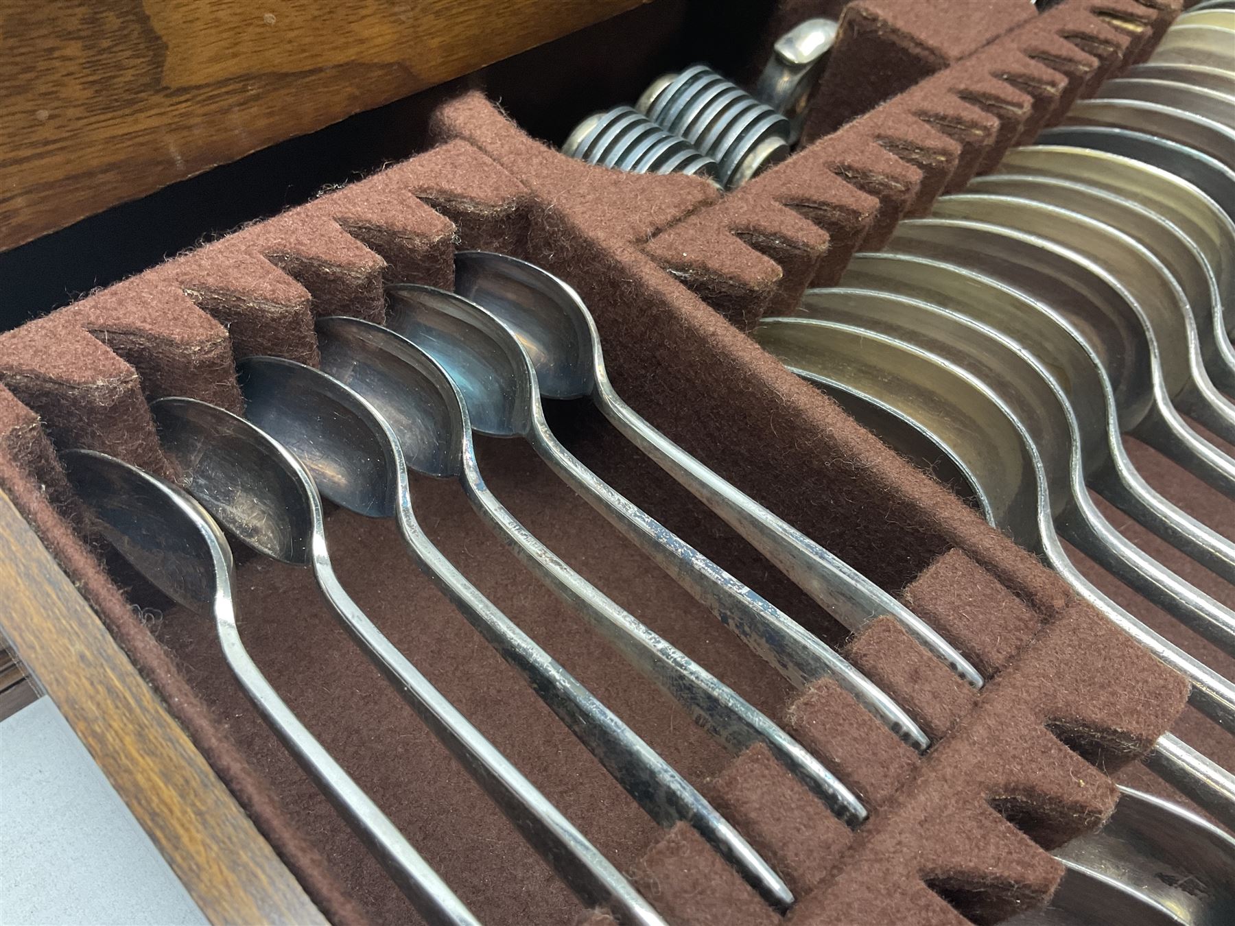 Elkington & Co part canteen of silver plated and stainless steel cutlery, to include simulated ivory handled examples, housed in oak and mahogany case, lock plate stamped 'Acme, British Made', W49cm D31cm H18cm