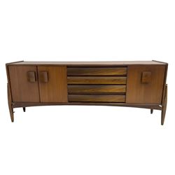 Elliots of Newbury (EoN) - mid-20th century teak sideboard, fitted with four central doors flanked by fall-front cupboard and a double cupboard, each with concave wooden handles