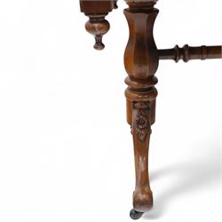 Mid Victorian walnut library table, plain top of rectangular form with moulded edge above frieze fitted with opposing drawers, table supported on a pair of turned and hexagonal carved baluster end standards, united by a turned stretcher terminating in scrolling sabre legs carved with acanthus and floral details, resting on ceramic castors, circa 1860