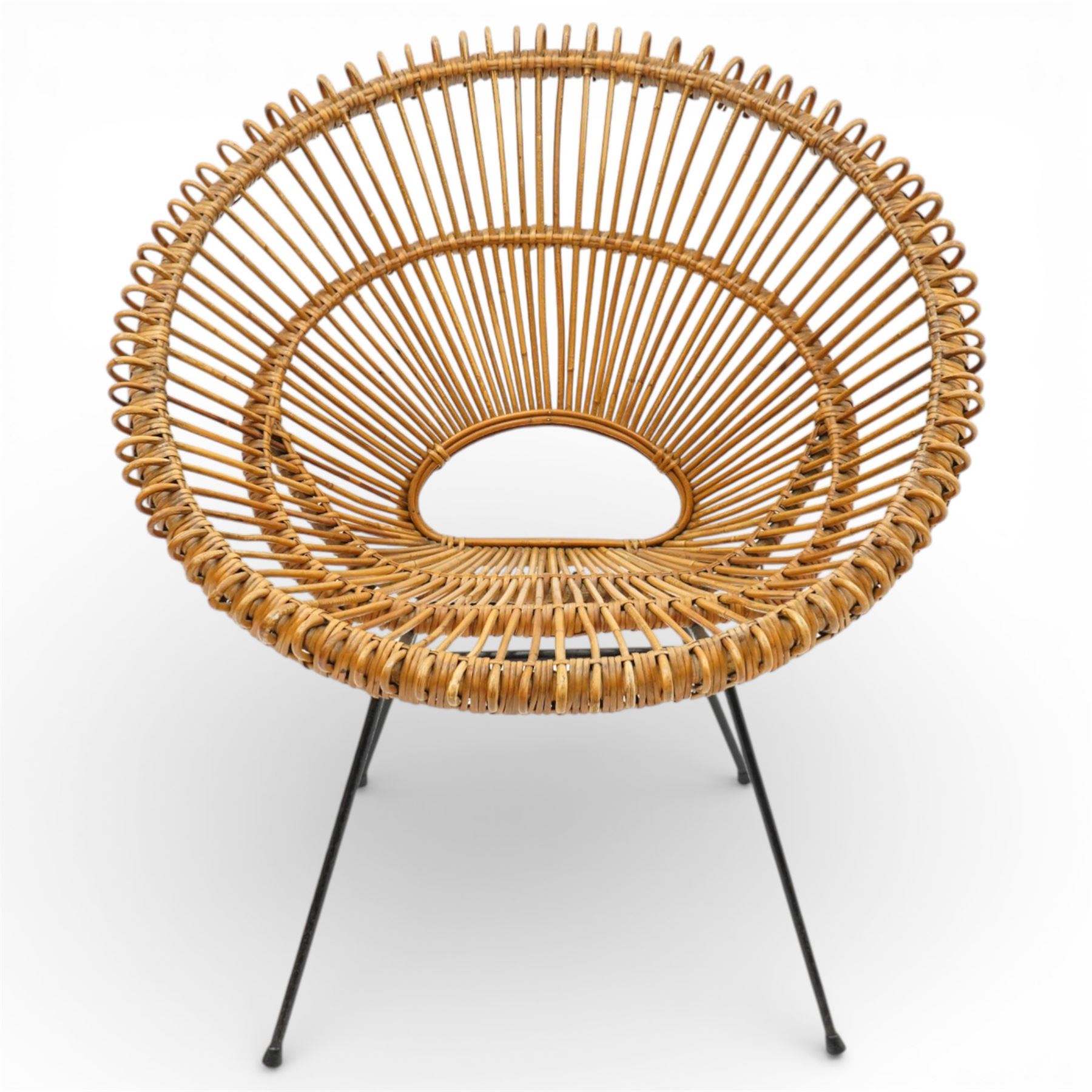 Janine Abraham and Dirk Jan Rol - Mid 20th century rattan sun lounger chair, circular openwork seat and back formed of radiating cane spindles with looped rim, raised on slender black metal tripod supports