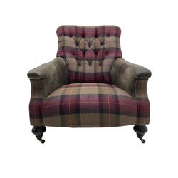 John Sankey - low armchair, buttoned back upholstered in tartan patterned fabric with contrasting grey leather, raised on turned and ebonised front feet with brass and ceramic castors, with matching foot stool