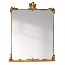 Large Victorian gilt wood overmantle mirror, shaped cresting rail with curled acanthus leaf pediment, the corners decorated with foliate C-scrolls and flower heads, curled foliage lower corner brackets, plain mirror plate 