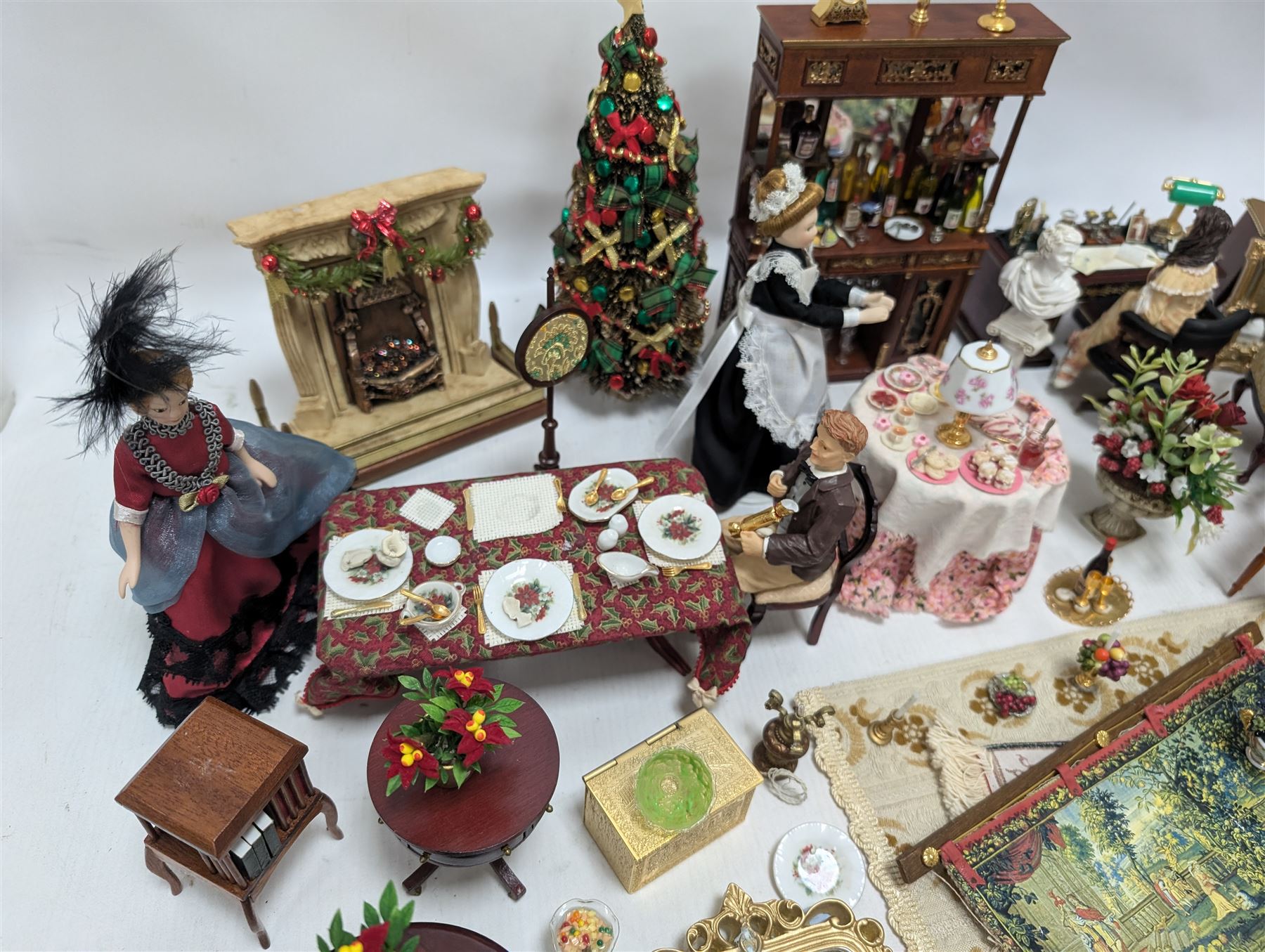 Dolls house living room and dining room furniture, including arm chairs, desk, fireplaces, dressers, tables, eight figures and a large collection of predominantly Christmas themed food, accessories and decorations