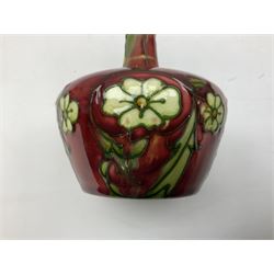 Three Minton Secessionist vases, with tube-lined stylised flower decoration, two upon a red ground and third upon a purple ground, all with printed mark to base 'Minton Ltd, No. 33', H13cm