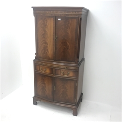 Reproduction Bevan Funnell mahogany serpentine front cocktail cabinet, two cupboards enclosing fitted shelves, single slide above two drawers and two cupboards, shaped bracket supports, W77cm, H153cm, D48cm