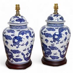 Pair of table lamps of baluster form, decorated with decorated with dragons chasing flaming pearls amongst clouds, on circular footed base,  H61cm including shades