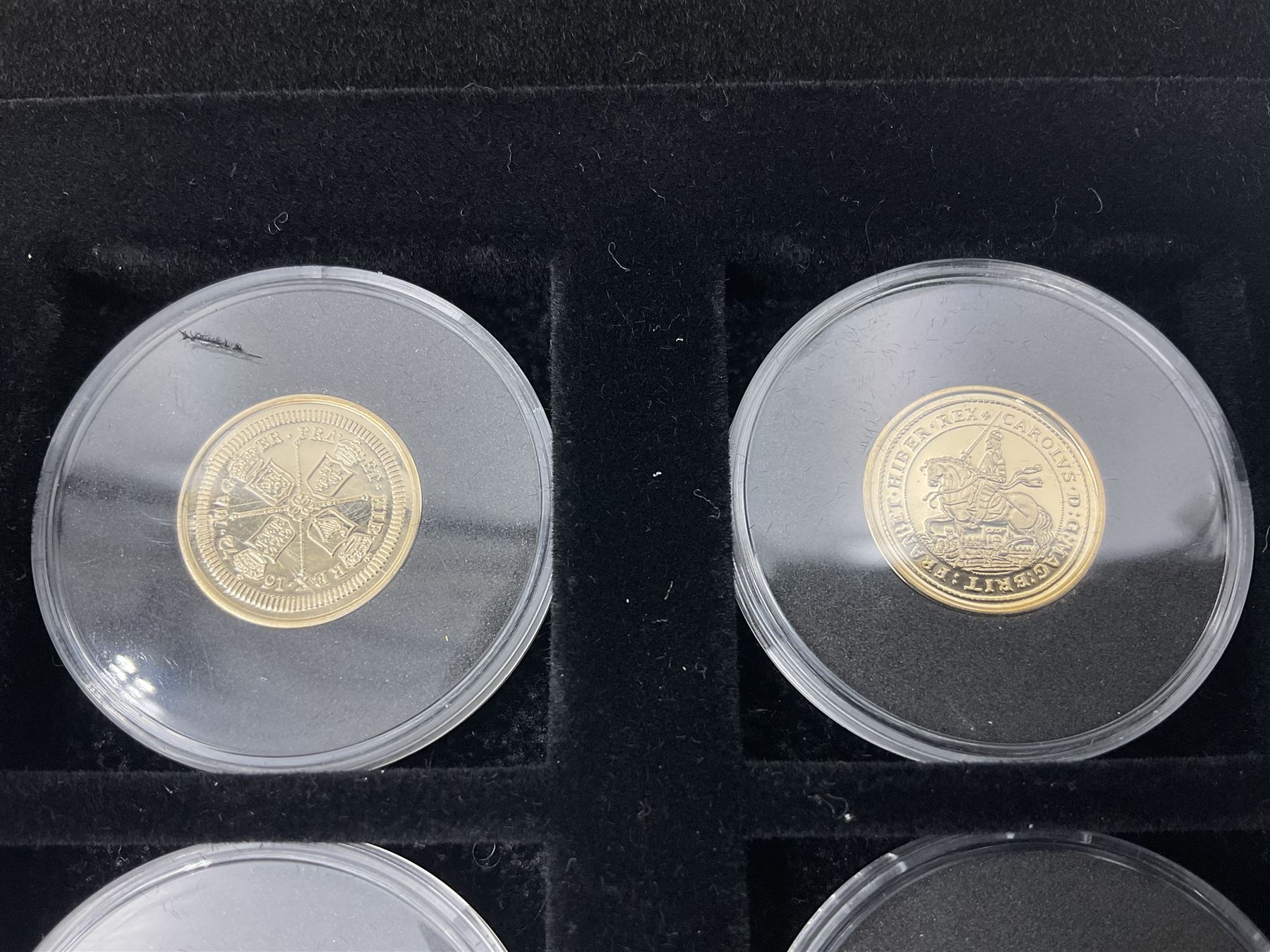 Sixteen hallmarked 9ct gold replica coins from 'The Historic Coins Of Great Britain Museum Gold Collection', housed in a Westminster display case, overall weight approximately 51.3 grams