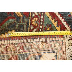 Antique Persian Qashqai dark indigo ground tribal rug, the busy field decorated with a geometric triple pole medallion surrounded by numerous stylised plant motifs with contrasting cyan spandrels, the multiple guard bands woven with stylised palmettes and foliage