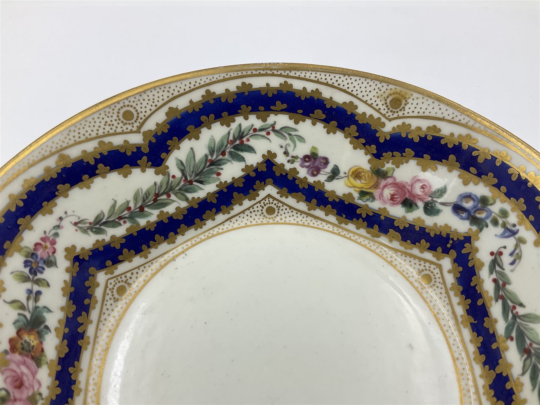Sèvres soft paste porcelain coffee can and saucer with date code for 1767, painted with floral and laurel leaf garlands within blue scalloped and gilt borders, interlaced LL monogram enclosing the date letter O above painters mark for Catrice, coffee can H7.5cm, saucer D15cm