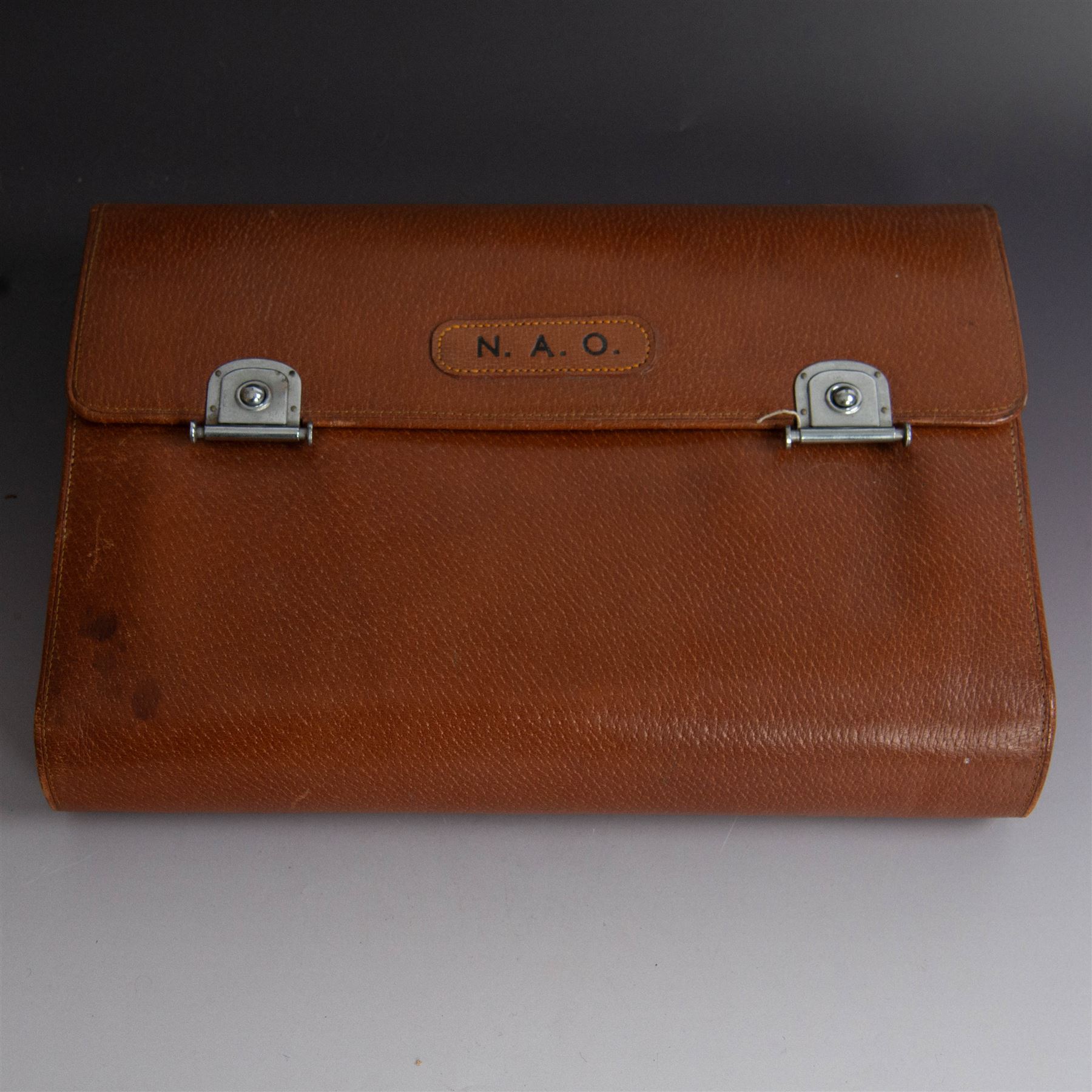 1920s gentleman's travelling case by Mappin & Webb Ltd, tan leather impressed with initials NAO, opening to reveal a compartmentalised interior containing silver mounted dressing table items, including a pair of silver mounted brushes, engraved NAO AMA 1918, hallmarked William Comyns, London 1911, five faceted glass jars and bottles with silver lids and a silver shaving brush holder, all hallmarked Mappin & Webb Ltd, London 1922, tan leather box containing razor, silver plated shoe horn, scissors and bevelled edge shaving mirror with easel support