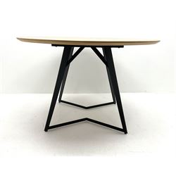 Light oak circular dining table on angular black finish metal base