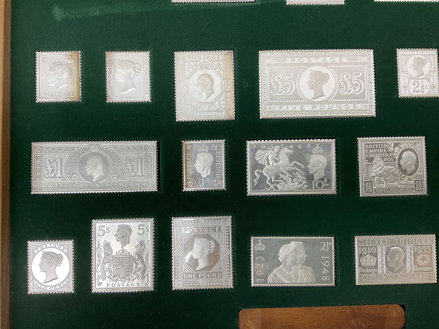 The Stamps of Royalty collection consisting of twenty-five sterling silver hallmarked stamp replicas, housed in a fitted wooden display case, with certificates, polishing cloth and certificates