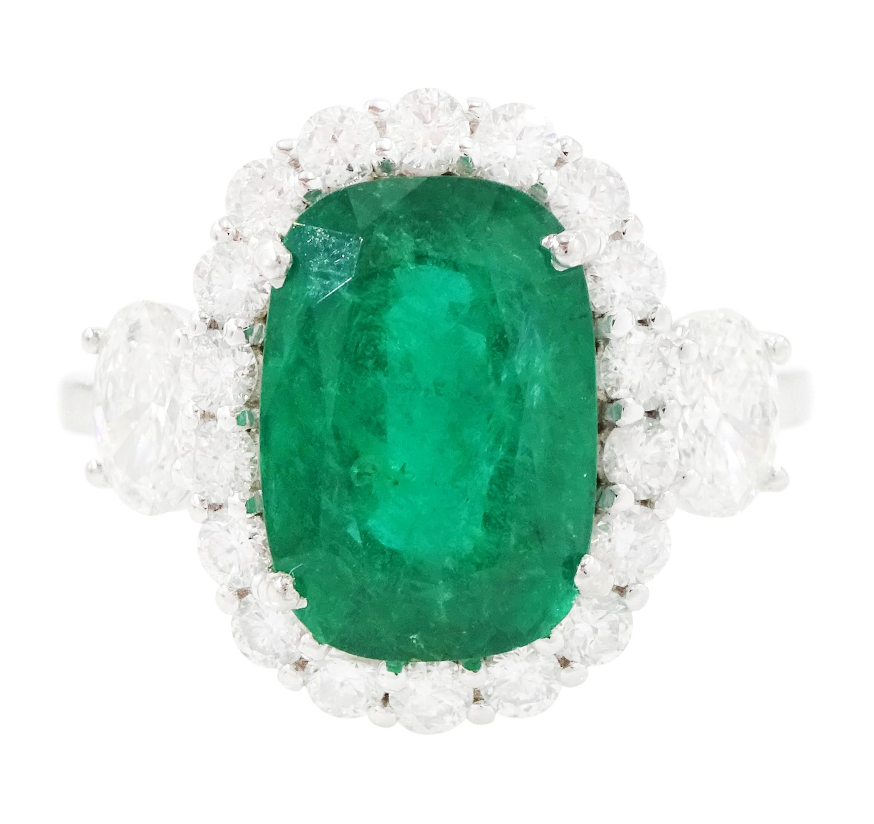 18ct white gold emerald and diamond cluster ring, single cushion cut emerald of approx 2.45 carat, surrounded by eighteen round brilliant cut diamonds, with a single oval cut diamond set either side, stamped, total diamond weight approx 1.05 carat