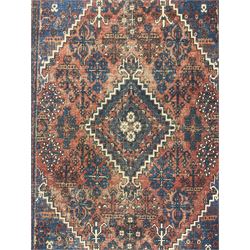 Persian Hamadan red ground rug, the field decorated with floral motifs with central lozenge medallion, guarded border decorated with repeating stylised plant motifs