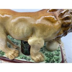 19th century Staffordshire style figure of a lion, modelled with paw resting upon globe, upon a naturalistically modelled rectangular base with canted corners and decorative border, L19cm