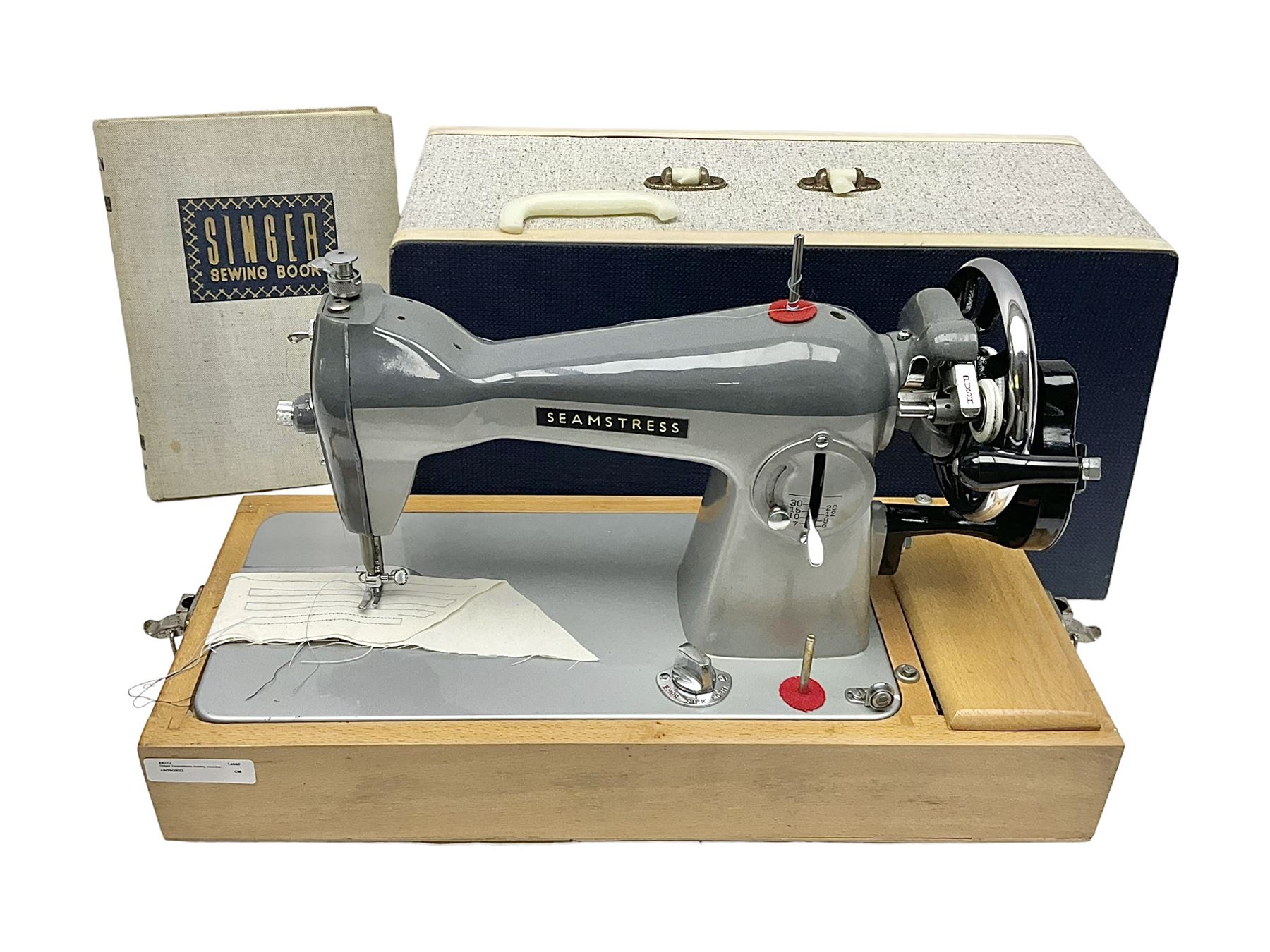 Seamstress sewing machine in case, together with a Singer sewing book