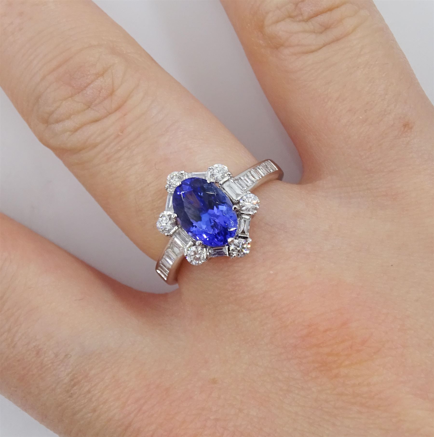 18ct white gold tanzanite and diamond cluster ring, oval tanzanite, with baguette and round brilliant cut diamond surround and baguette cut diamond shoulders, stamped 750, tanzanite approx 1.80 carat, total diamond weight approx 0.55 carat