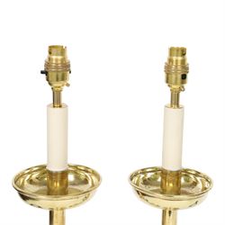 Pair of early 20th century brass alter candlesticks converted to table lamps, each with stepped and spreading circular base leading to a double hexagonal knopped column, and plain socket above inverted domed circular drip pan, the socket with light fitting, overall H49cm