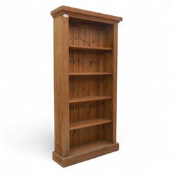 Contemporary oak open bookcase, with moulded cornice above five fixed shelves and boarded back, on plinth base