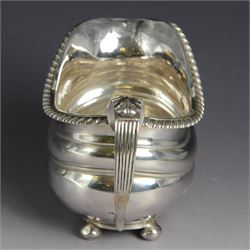 George III silver milk jug, of oval form with oblique gadrooned rim and acanthus leaf capped handle, upon four bun feet, hallmarked London 1819, maker's mark worn and indistinct, H10cm
