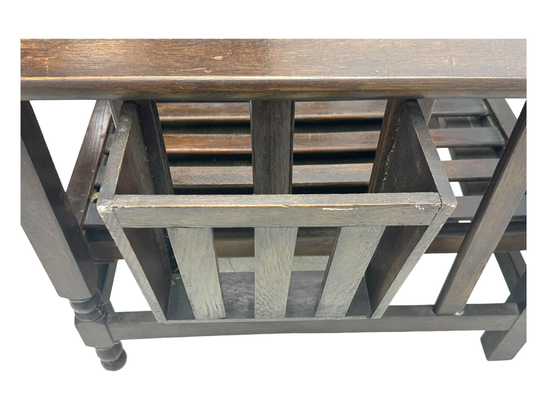 Late Victorian oak steamer chair, adjustable slatted backrest with grooved crest rail, wide armrests extending to a sliding adjustable footrest, open frame sides with vertical slats, side magazine rack and collapsible table, raised on turned front supports