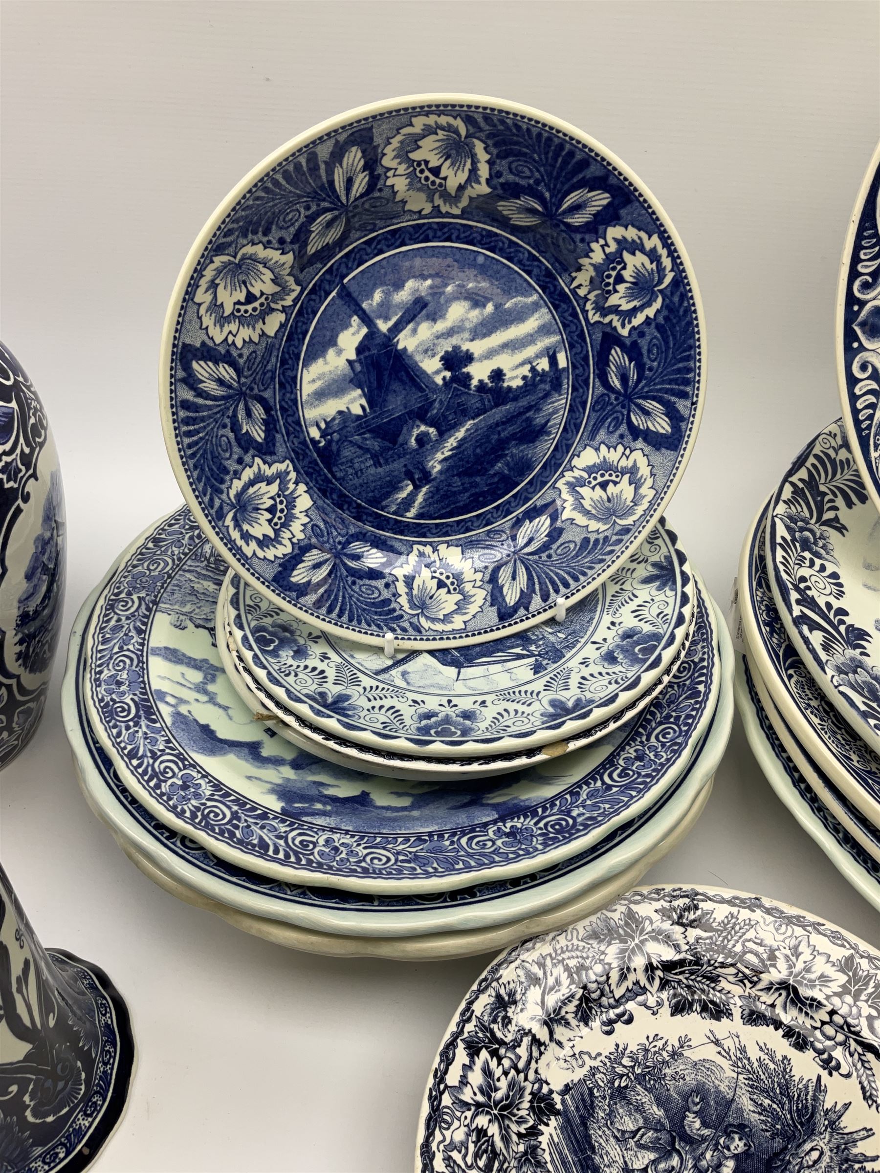 A large collection of modern transfer printed Delft ware, to include large baluster vase, H42cm, two jars and covers, largest H40cm, pair of tapering cylindrical vases, H31cm, and a number of plates of various size and design. 