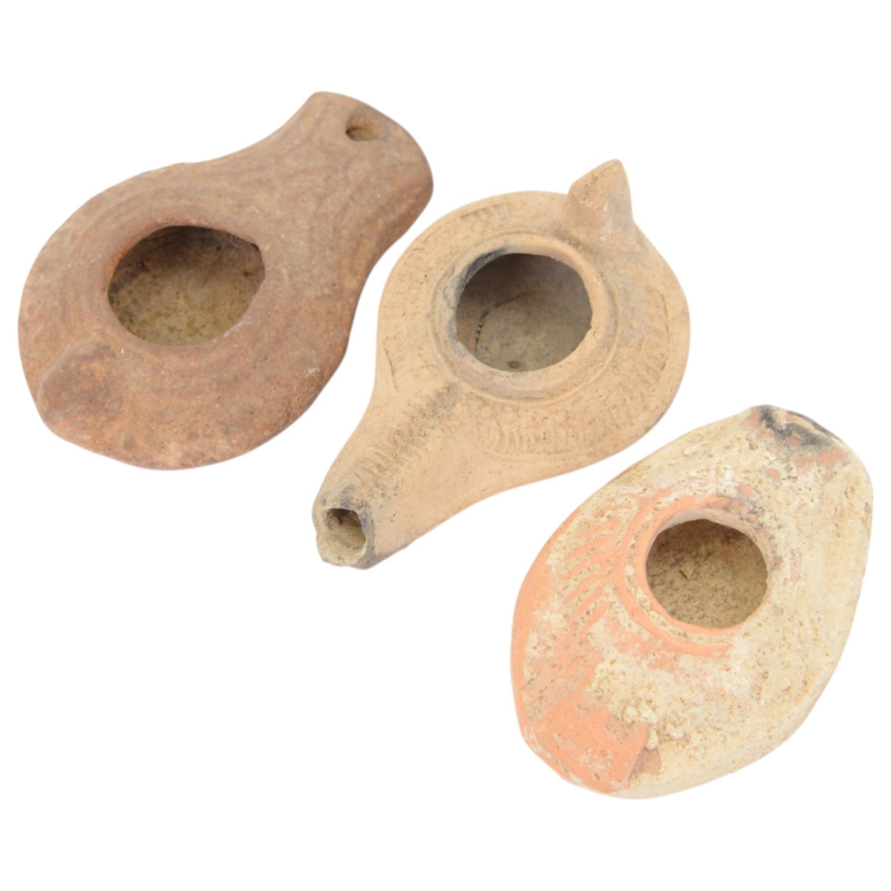 Antiquities; two decorative terracotta Byzantine oil lamps, 4th - 5th century, with decorative spouts, together with two similar examples