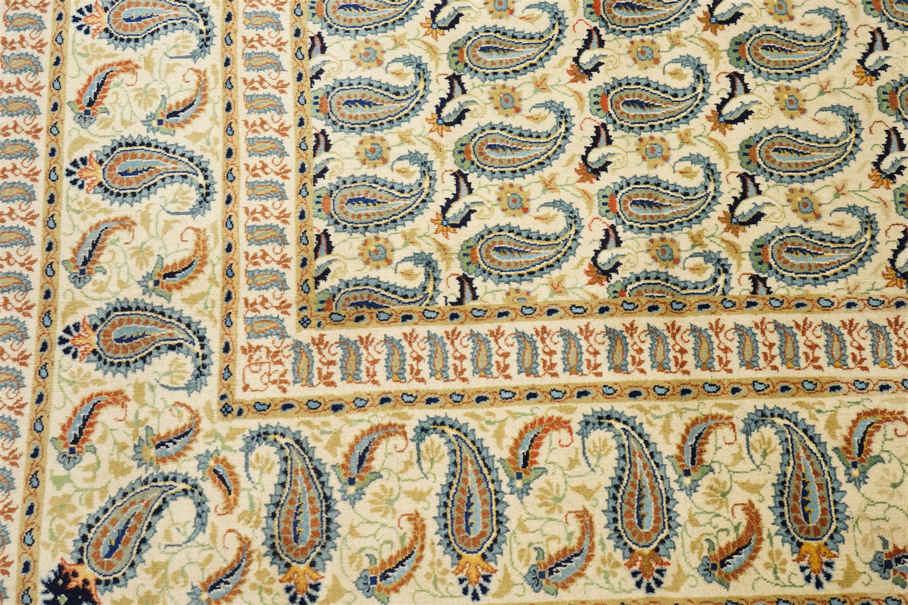 Central Persian Kashan hand-knotted carpet, ivory field densely decorated with all-over repeating botehs motifs, arranged in rows and enclosed by scrolling vine work and floral sprays, in a palette of indigo, pale blue, sage green and muted terracotta tones, within ivory borders of small boteh motifs flanked by border within large scale boteh motifs with multiple guard stripes, with cotton fringe ends 