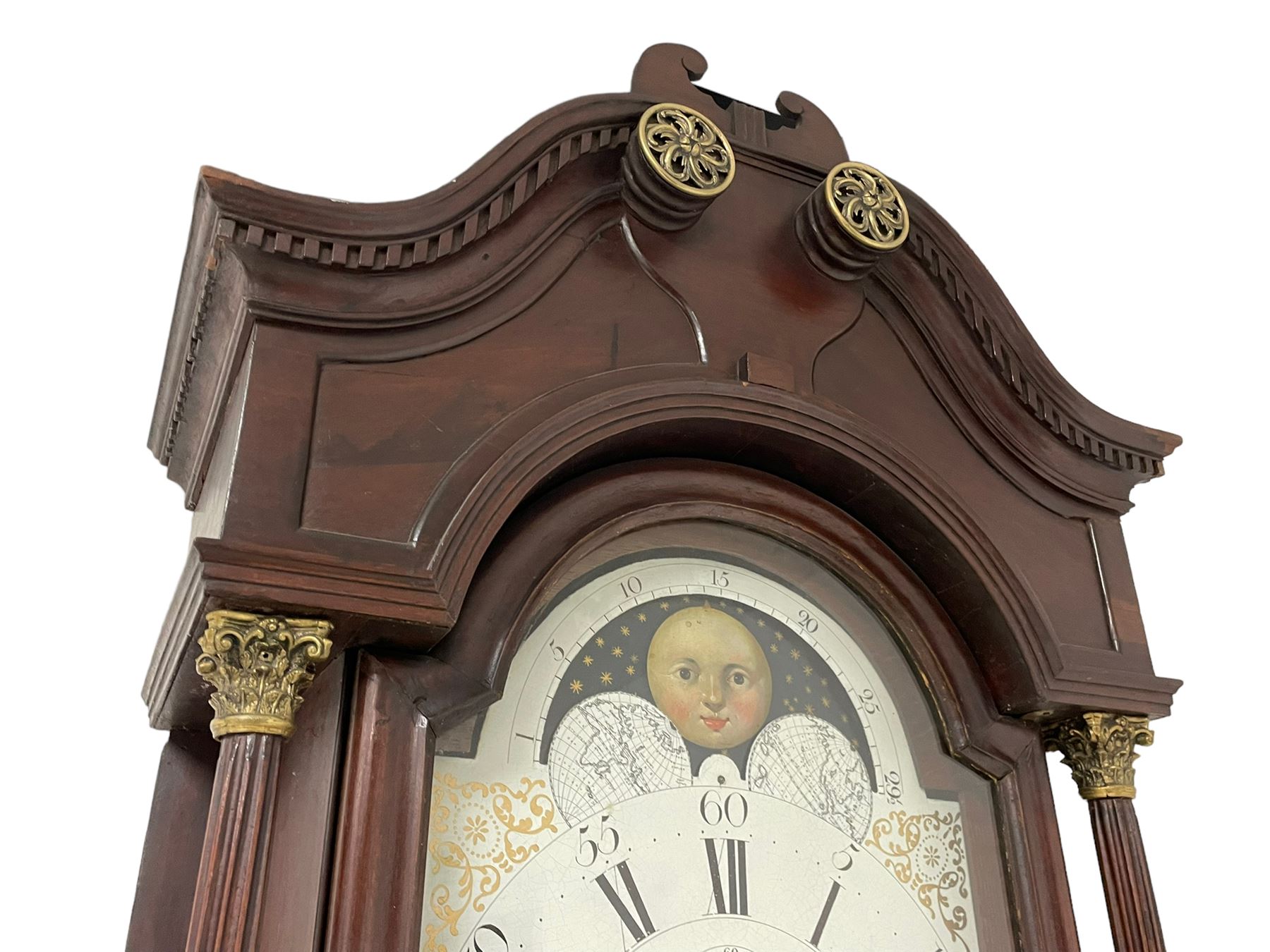W. Phillips of Bromyard - 8-day mahogany longcase with a painted moon roller dial, c 1790,
swans neck pediment with dog tooth moulding, raised carving and  brass paterie, break arch hood door beneath flanked by reeded pilasters with brass Corinthian capitals, trunk with a blind fret, reeded quarter columns and long wavy topped door,
Plinth with a deep moulding and canted corners raised on a shaped base, painted dial with gesso spandrels, Roman numerals, five minute Arabic's and minute dots, with steel hands, seconds dial and square date aperture, dial pinned to a rack striking movement with an anchor escapement, striking the hours on a cast bell. A clockmaker by the name of John Phillips is recorded as working in Bromyard (Worcs)  in the early to mid 18th century, certainly by 1770-90. W. Phillips was possibly an unrecorded son or brother also working in the same family clockmaking business during the later part of the 18th century.
