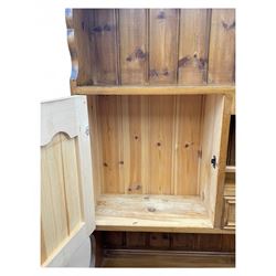Traditional vintage pine kitchen dresser with scrolled cornice and rack with long shelf above a galleried shelf flanked by three short drawers and two cupboards, the base with three long drawers above three cupboards on plinth base  