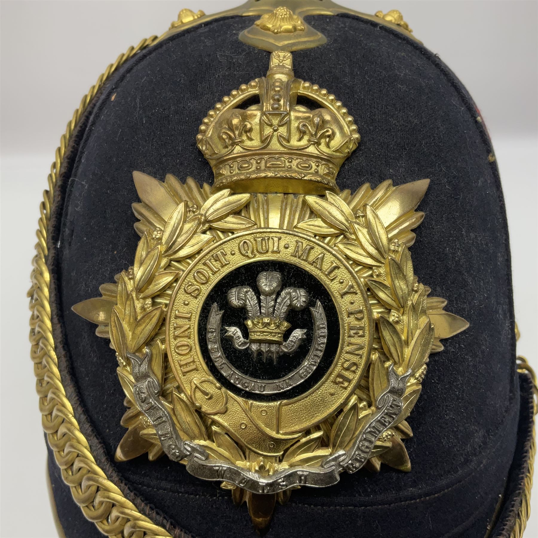 Post-1902 Welsh Regiment Officer's Home Service Blue Cloth Helmet with gilt metal King's crown helmet plate to the front, a removable spike to the top on a shaped cruciform base with rosette fittings, rosette side bosses, brass trim to the front peak, and leather and velvet backed chin scales, with sweat band, the interior with the remains of a makers label at the address 1,3 & 5 Lexington Street, Golden ? London W (presumably Hobson & Sons)
