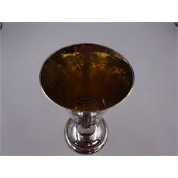 Modern limited edition silver goblet, a replica of the original silver chalice of Lincoln Cathedral, with hand planished decoration, and engraved band of laurel leaves to bowl, with gilt interior, upon waisted stem and circular stepped foot, no. 144/200, hallmarked John Cussell, London 1977, H15cm